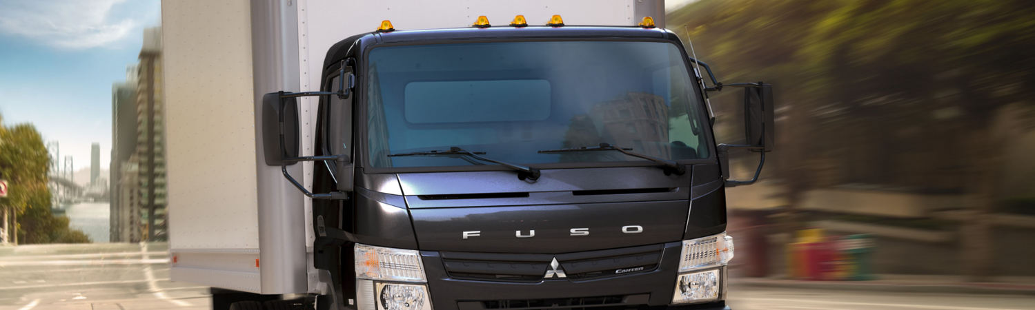 Black Mitsubishi Fuso Commercial Truck Driving Through City