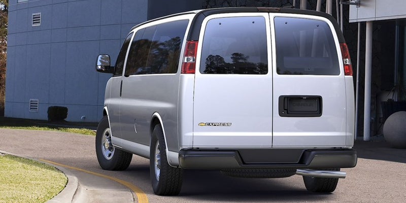 Silver Chevrolet Express passenger van shown from the rear three-quarter view