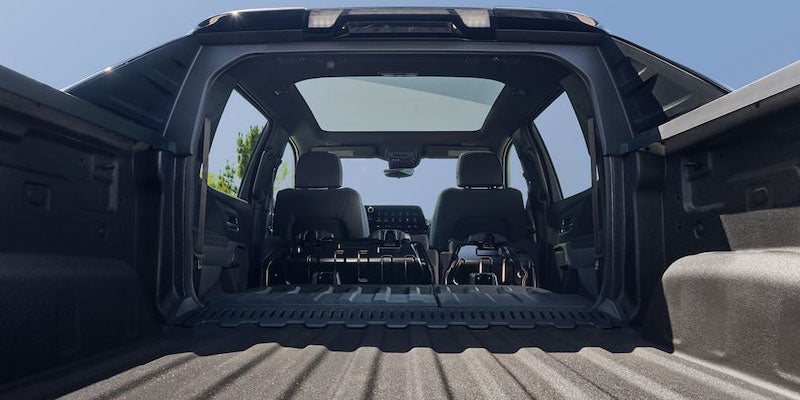 View from the Chevrolet Silverado EV truck bed with the Midgate and rear cabin pass-through open